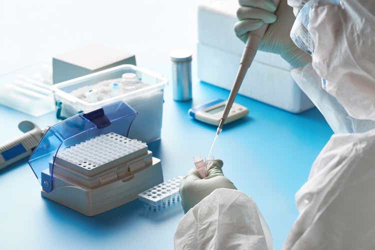 SARS-COV-2 pcr diagnostics kit. Epidemiologist in protective suit, mask and glasses works with patient swabs to detect specific region of 2019-nCoV virus causing Covid-19 viral pneumonia.