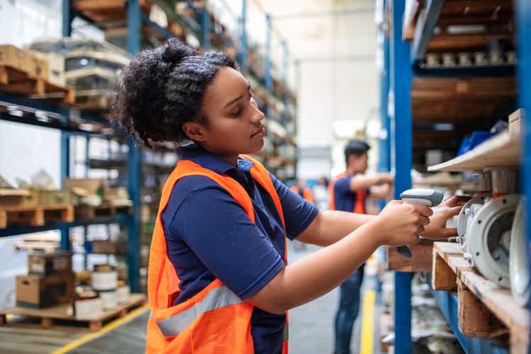 Warehouse worker checking cargo on shelves with scanner