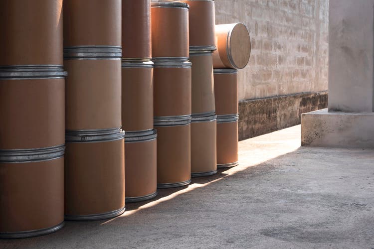 Side view of many old brown paper buckets [paper tank] for reuse on concrete floor