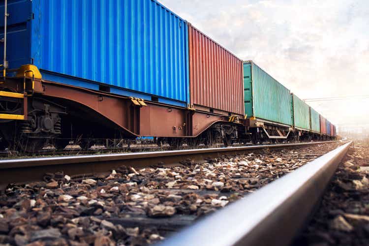 Train wagons carrying cargo containers for shipping companies.