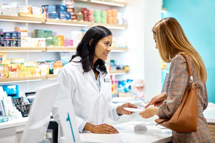 Female customer asking pharmacist at checkout