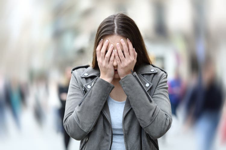 Woman suffering anxiety attack on city street