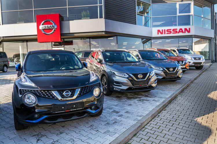 Nissan motor company car standing in front of dealership building