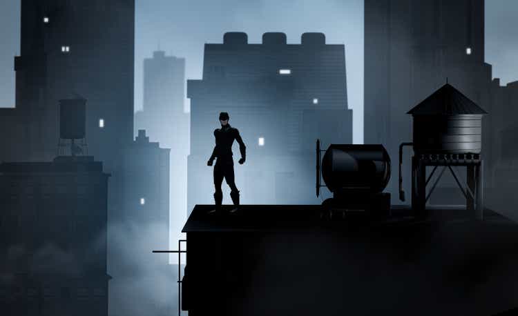 Superhero in costume on rooftop overlooking cityscape