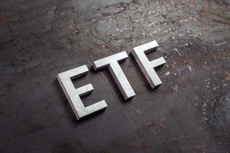 the abbreviation word etf - Exchange Traded Fund - laid with silver letters on raw rusted steel sheet surface in slanted diagonal perspective