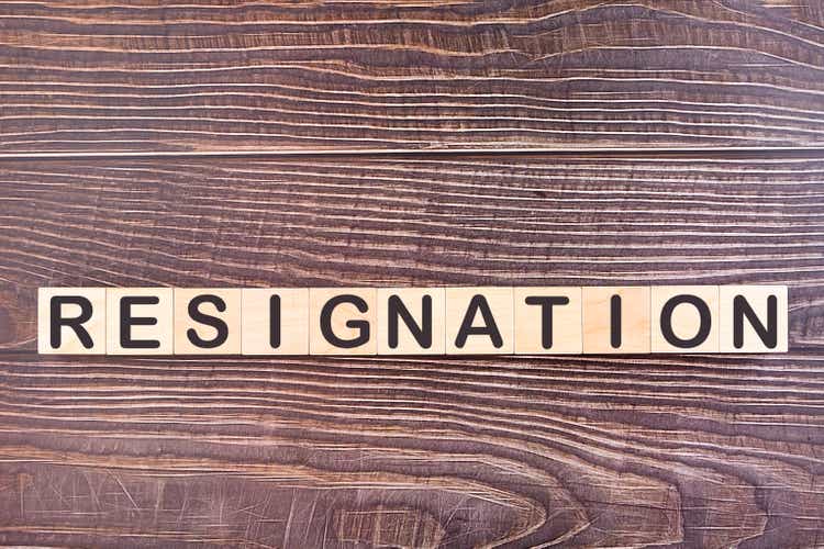 Text Resignation is written on wooden building blocks lying on an office desk. Business concept.n letter to his boss, change of job, unemployment, resign concept.