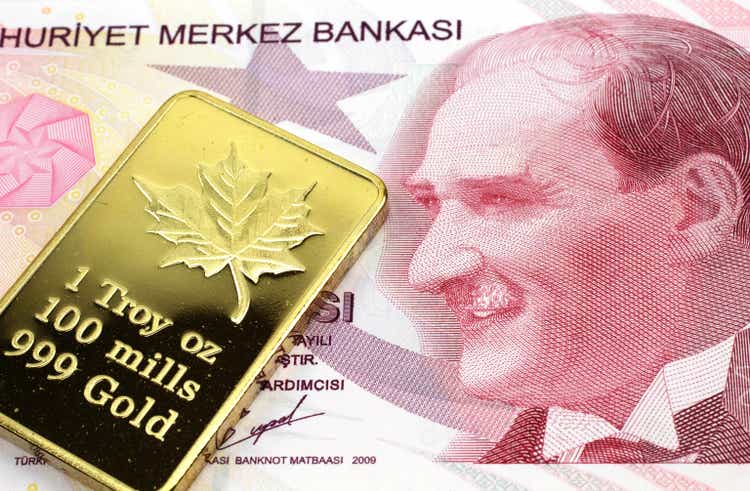 A red ten lira note from Turkey with a gold bar in macro