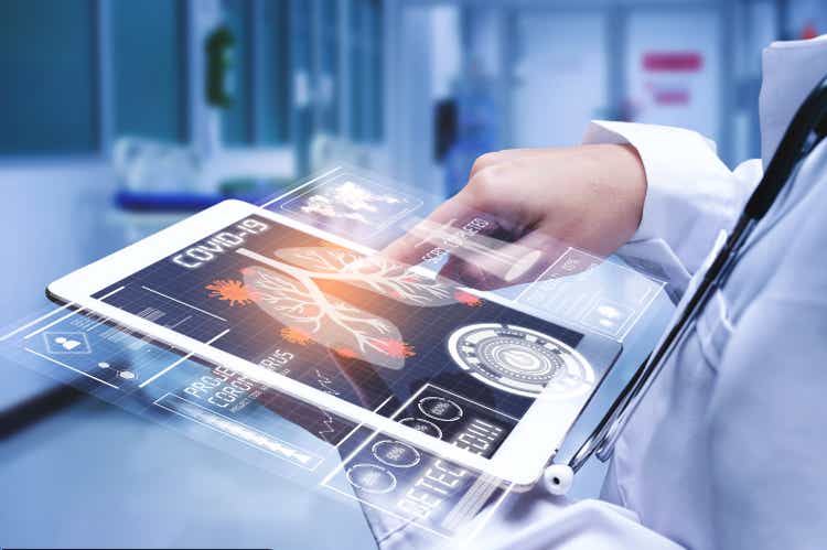 Doctor analyzing COVID-19 or coronavirus test result with futuristic tablet