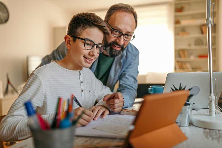 Happy father helping son with homework