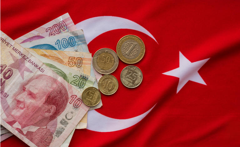 Close-up of Turkish Lira on Turkish Flag.