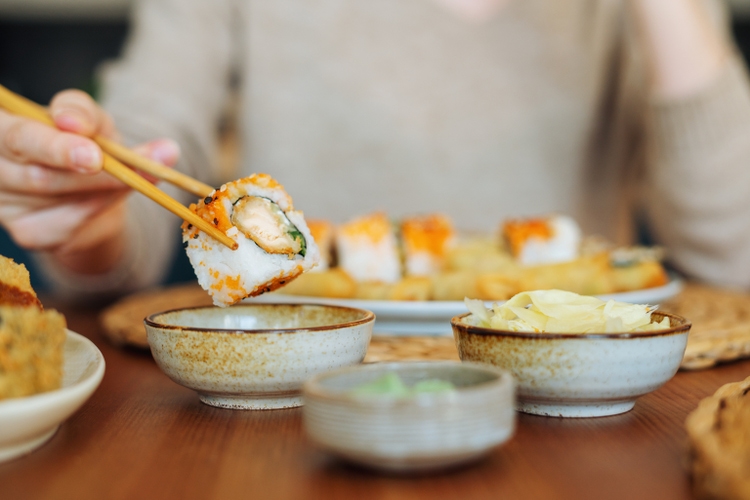 Woman eating sushi rolls