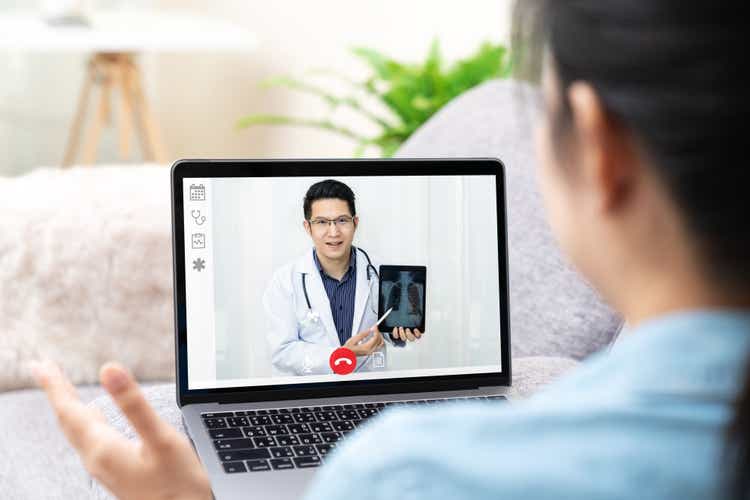 Asian chinese doctor video conference call online talking for follow up remotely with medical coronavirus result at home. Online healthcare digital technology service, counselor and internet support.