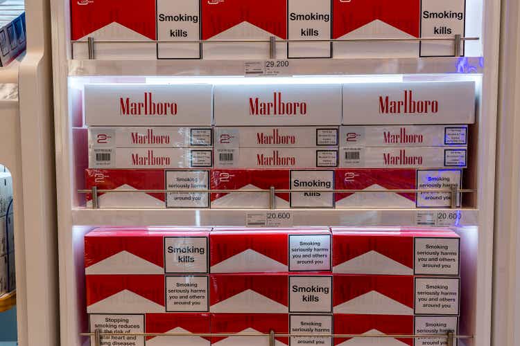 Cigarettes department at a duty free segment store with many big packs of Marlboro on sale on a shelf in shop airport