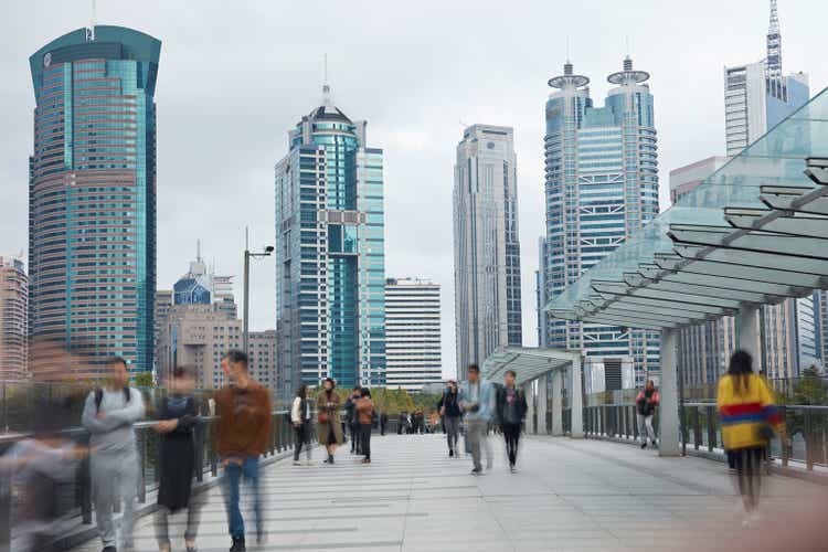 Crowd on bridge against buildings in city