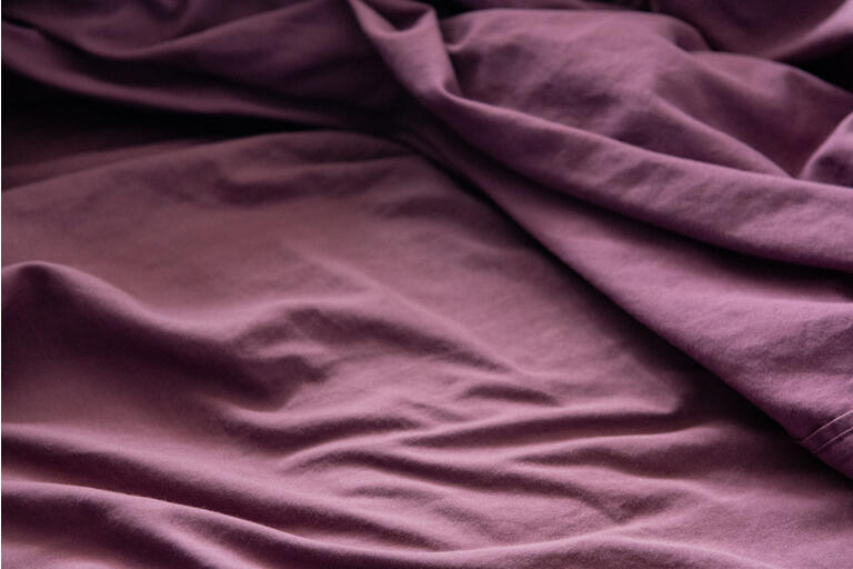 Close up Texture of Purple Wrinkled Bed Sheets at Home During Lockdown