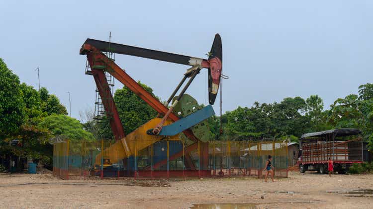 Women walking near a producing oil well near La Dorada village on a sunny day