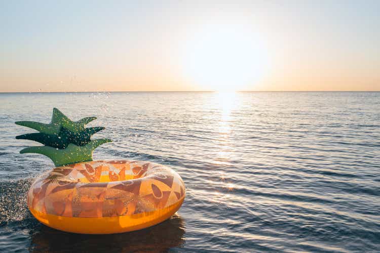 Inflatable pineapple floating in sea. Close up shot of rubber ring with space for text.