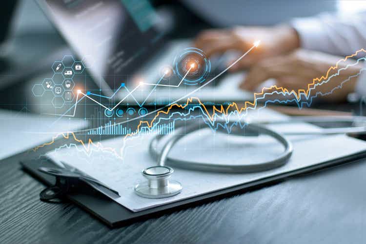 Healthcare business graph data and growth, Stethoscope with doctor"s health report clipboard on table, Medical examination and doctor analyzing medical report on laptop screen.