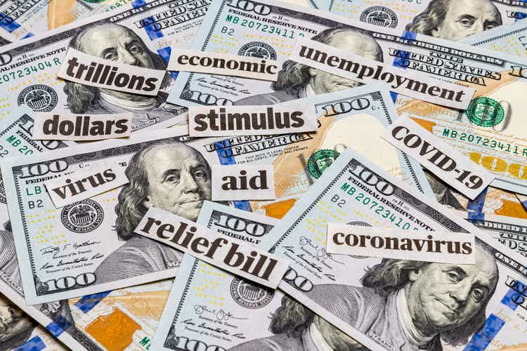 Covid-19 coronavirus newspaper headlines and 100 dollar bills. Stimulus aid relief bill, unemployment and recession concept