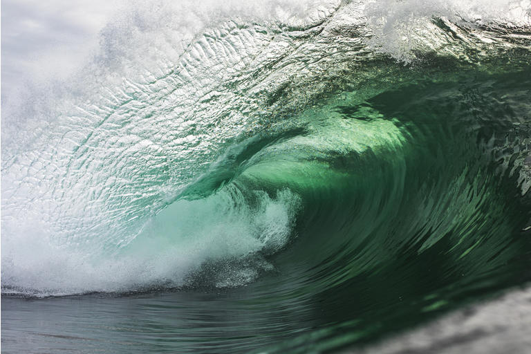 Emerald green wave breaking in the ocean