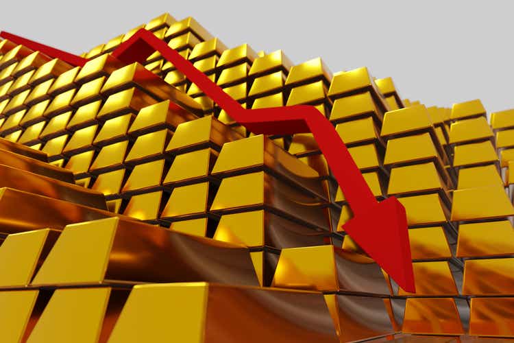 Gold prices falling in a bearish market. Red arrow going down over gold bullion bars. Concept digital 3D render.