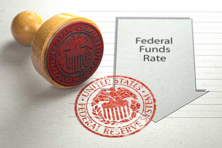 Federal funds rate decrease. Arrow with cut of federal fund rate and stamp of federal reserve FRS symbol.