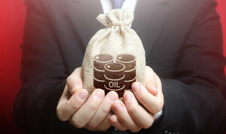 A man is holding a bag with oil barrels. Offer the purchase of oil and futures at competitive price, discounts and bonuses. Deferment of payment. Negative energy prices. Lack of storage space