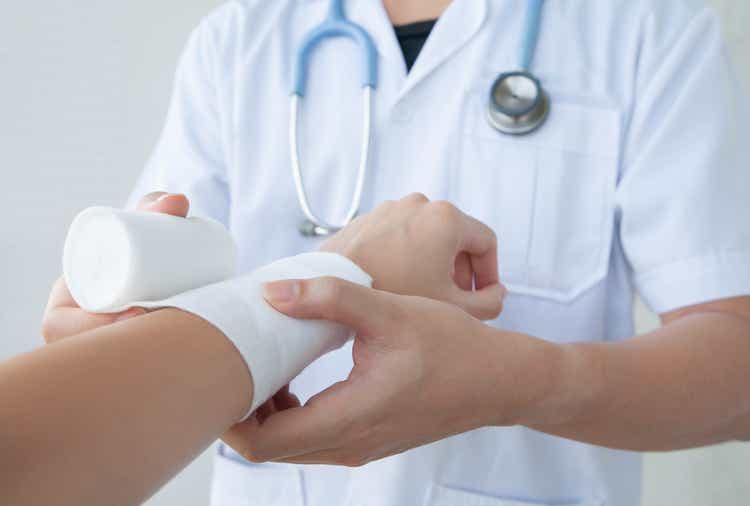 Doctor bandaging the wrist. Concept of first aids and treatment in wrist injuries.