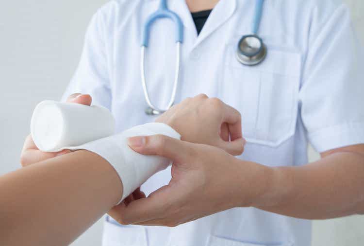 Doctor bandaging wrist. Concept of first aid and treatment of wrist injuries.