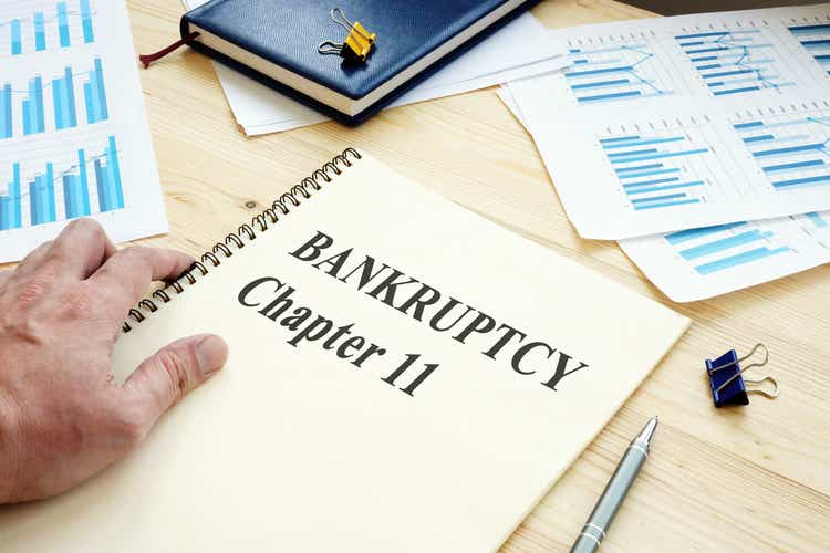 Businessman reads Bankruptcy Chapter 11 book.