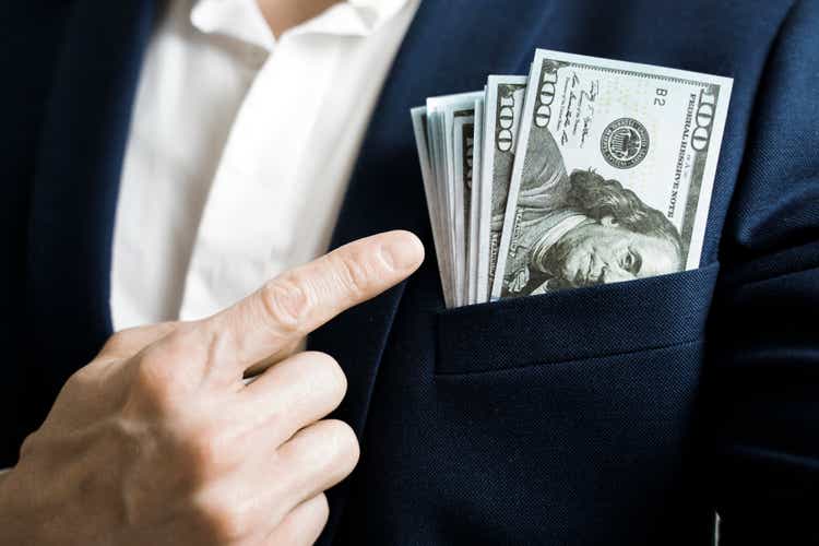 Money success concept. 100 dollar bills in businessman jacket pocket. Symbol of success and wealth