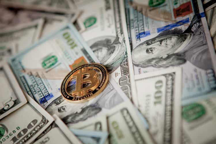 Golden Bitcoin on US dollar bills. Electronic money exchange concept