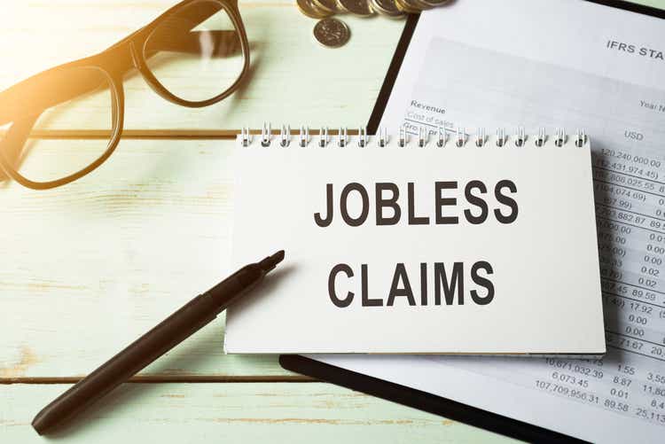 The phrase Jobless claims on a banner in hand. Human holds a cardboard with an inscription. Unemployment crisis. Economy crashed. Financial collapse. Recession. Finance. Employee