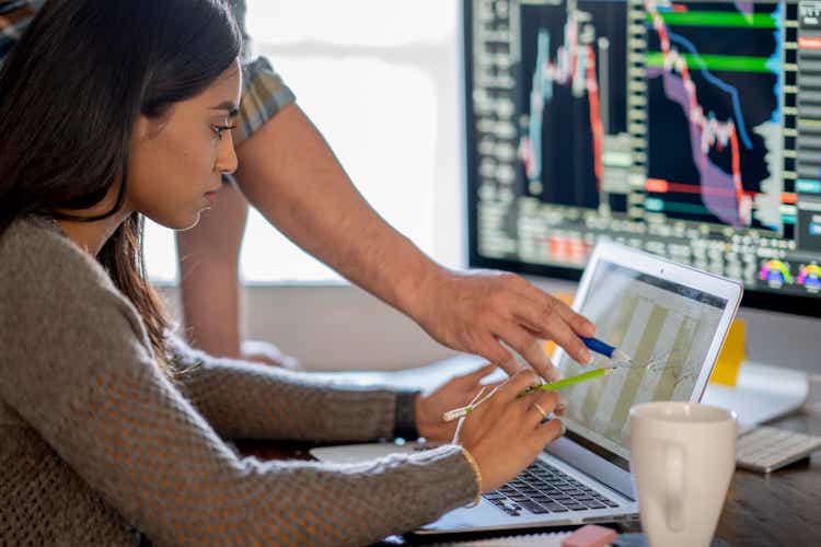 Young business woman day trading from her dining room table