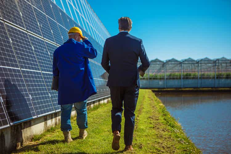 Two male engineers at a solar panel site