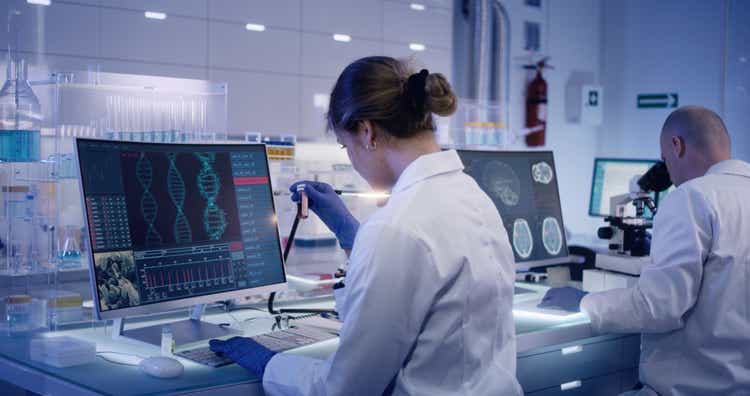 Multi ethnic research team studying DNA mutations. Female doctor in foreground