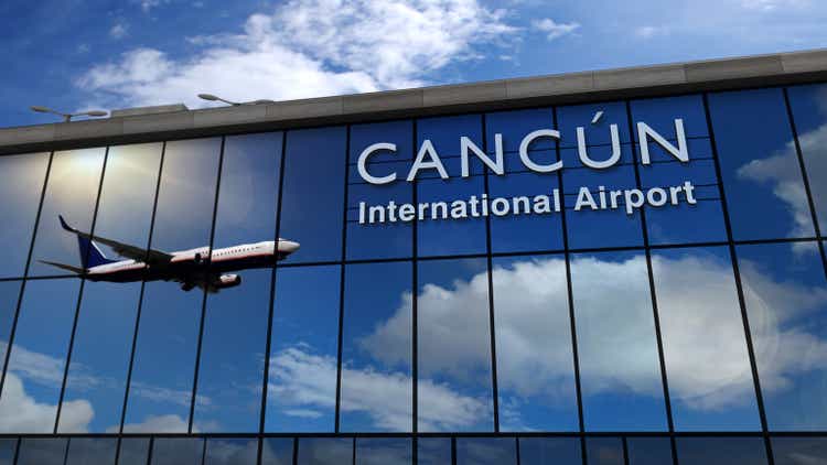 Aterrizaje de avión en Cancún México reflejado en terminal
