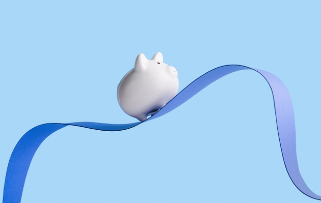 Piggy bank riding paper wave