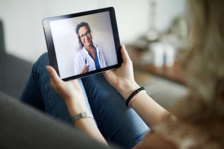 Young woman having online meeting with female healthcare person