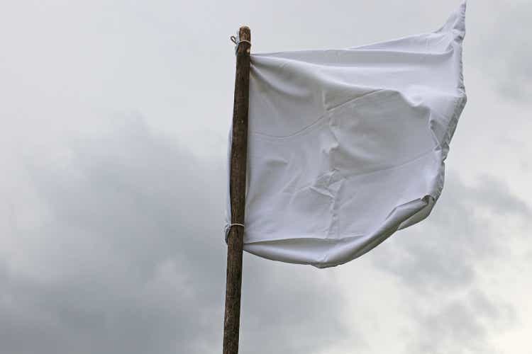 The white flag against the gray sky.