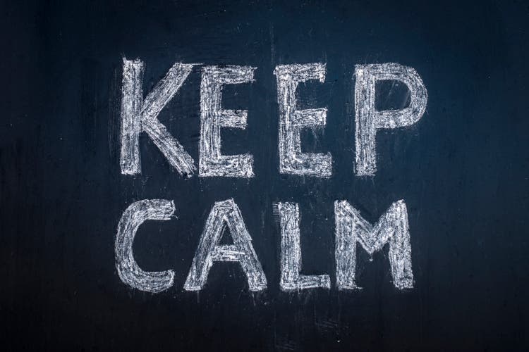 Keep calm written in chalk on a black board.