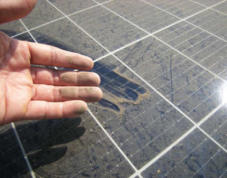 Dirty Hand after Rubbing Dusty Solar Panel