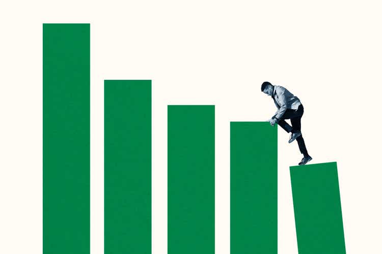 Young man climbing up on green bar graphs