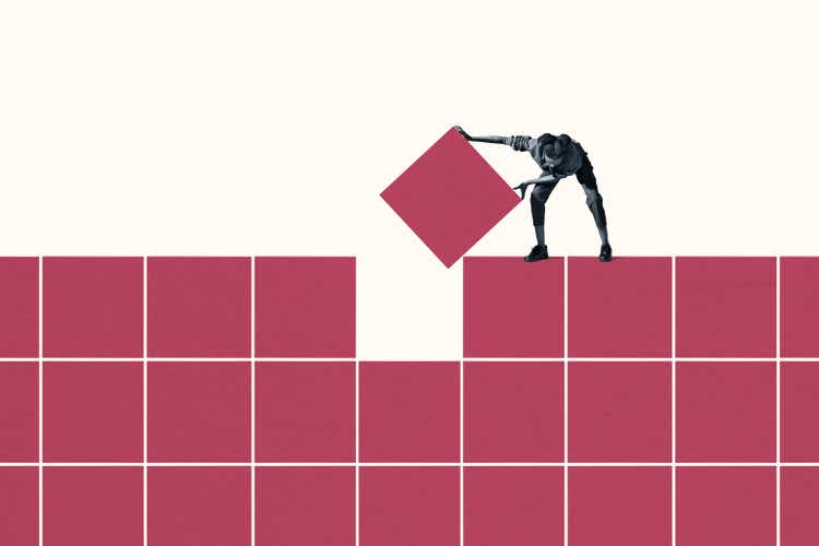 Woman positioning final magenta block in grid