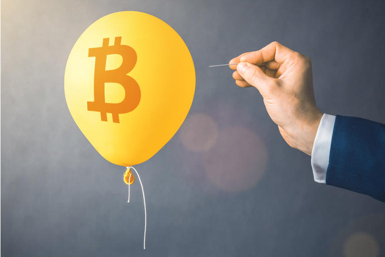 Bitcoin cryptocurrency symbol on yellow balloon. Man hold needle directed to air balloon. Concept of finance risk