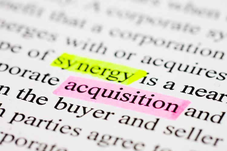 The words acquisition and synergy highlighted in business text