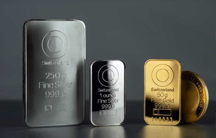 Silver and gold bars and coin on a dark