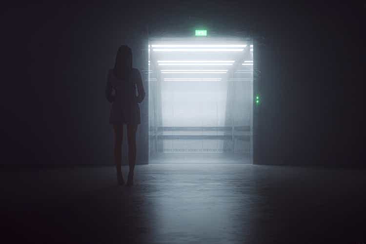 Woman standing in front of elevator at night