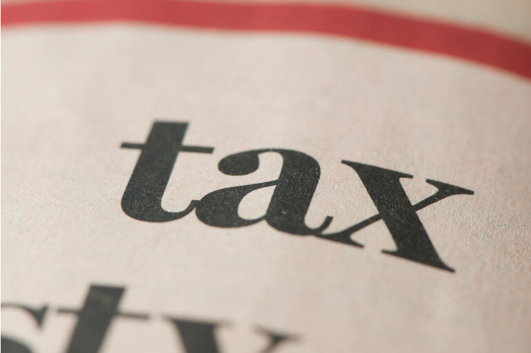 Tax written in newspaper, copy space, close-up