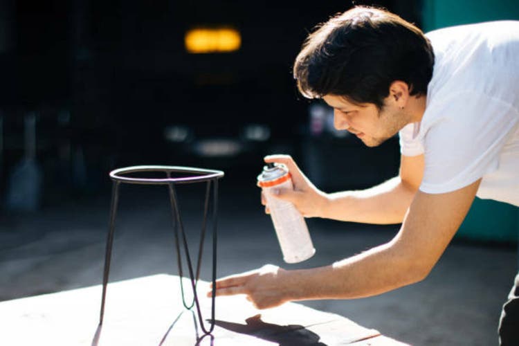 Young man renovating furniture at home